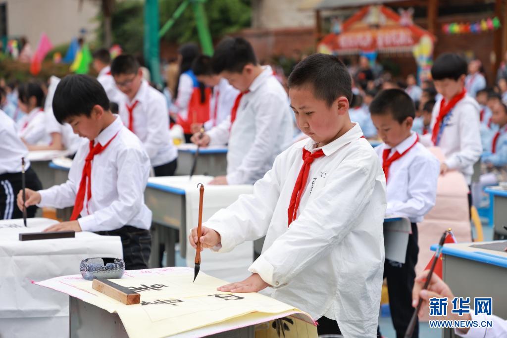 小学生们现场进行书法展示,书写内容以庆祝建党100周年和积极向上的