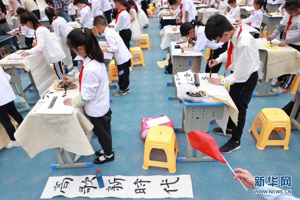 小学生们现场进行书法展示,书写内容以庆祝建党100周年和积极向上的